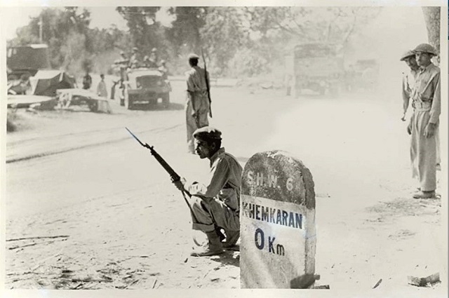 a pakistani soldier sitting next to a milestone in the indian town of khem karan during the 1965 war photo ispr