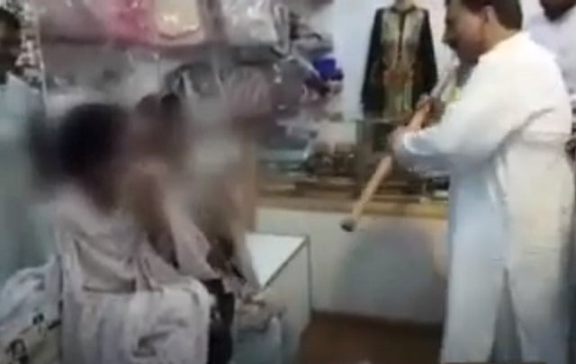 a man beating women with a bamboo stick in a shop in lahore screengrab a man beating women with a bamboo stick in a shop in lahore screengrab