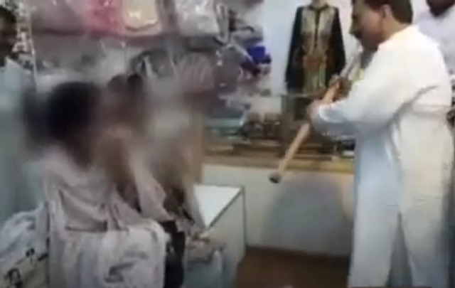 a man beating women with a bamboo stick in a shop in lahore screengrab