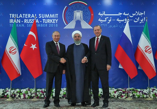 a handout picture provided by the office of iranian president hassan rouhani centre shows him holding hands with turkish president recep tayyip erodgan right and russian president vladimir putin in tehran on september 7 2018 photo afp