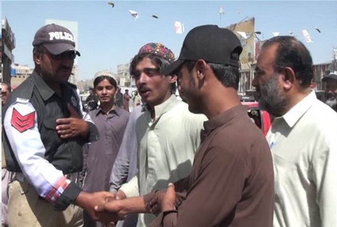 a police officer shakes hands with pedestrians during the final day of the affability week in quetta photo express