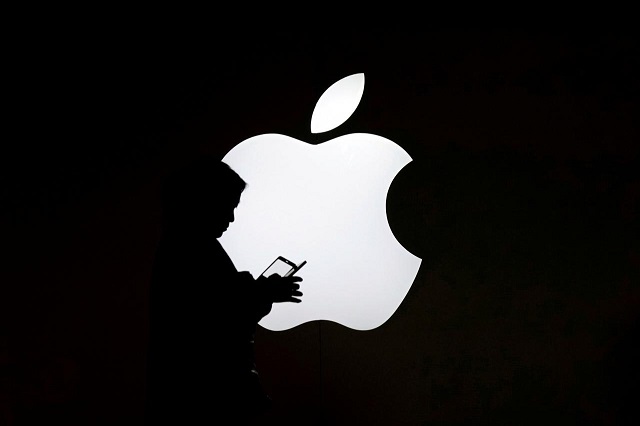 a woman looks at the screen of her mobile phone in front of an apple logo outside its store in shanghai china july 30 2017 photo reuters