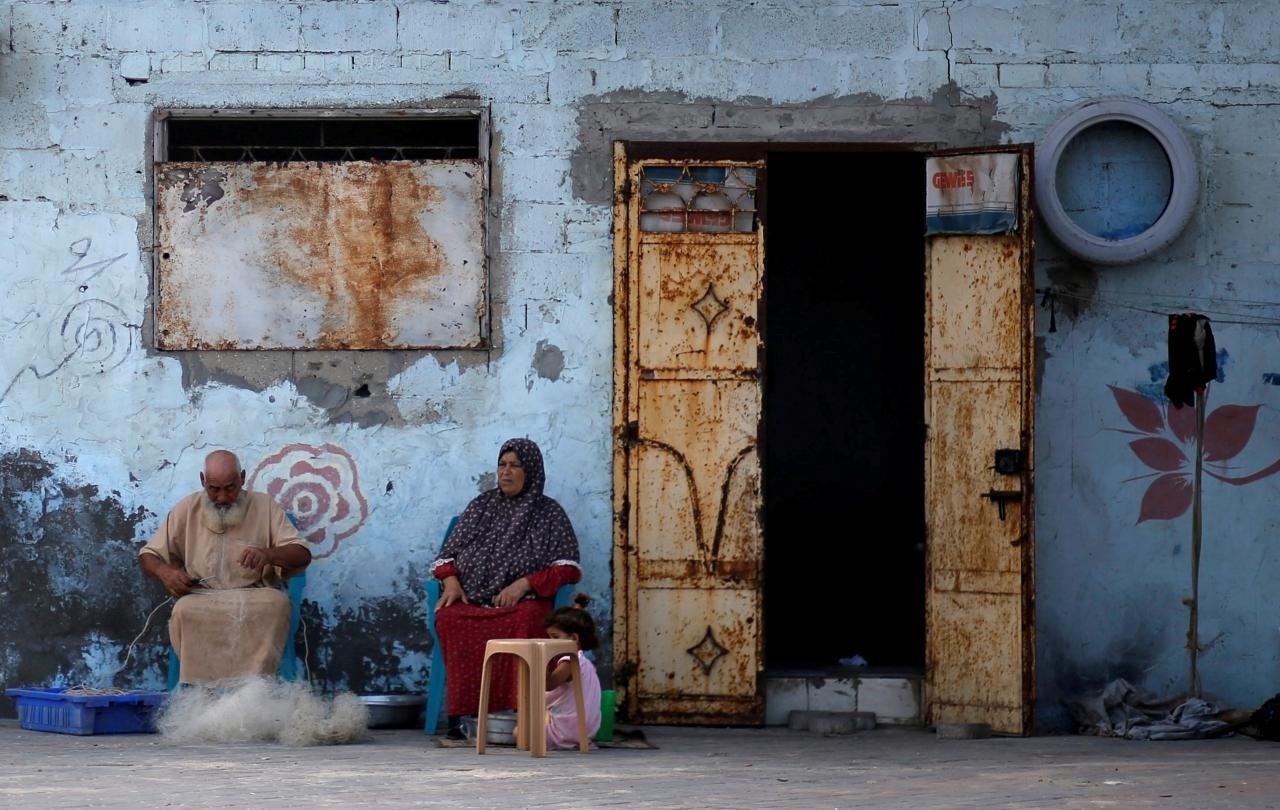 a palestinian man repairs a fishing net outside his house at al shati refugee camp in gaza city photo reuters