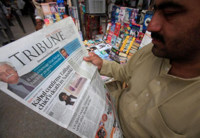 a man reads a newspaper containing news photo reuters a man reads a newspaper containing news photo reuters
