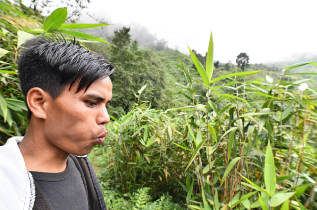 a villager whistling as he calls to a friend in a field in kongthong village photo afp