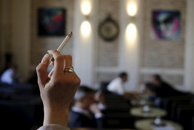 a woman holds a cigarette in a cafe photo reuters a woman holds a cigarette in a cafe photo reuters