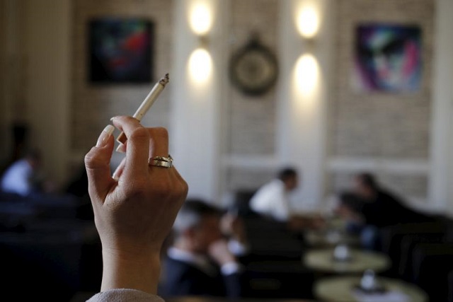a woman holds a cigarette in a cafe photo reuters