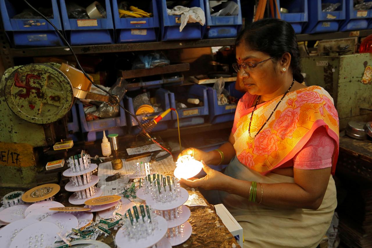 a woman tests led bulbs after installing them onto a grid to make indicator lights inside an electrical manufacturing unit in mumbai photo reuters