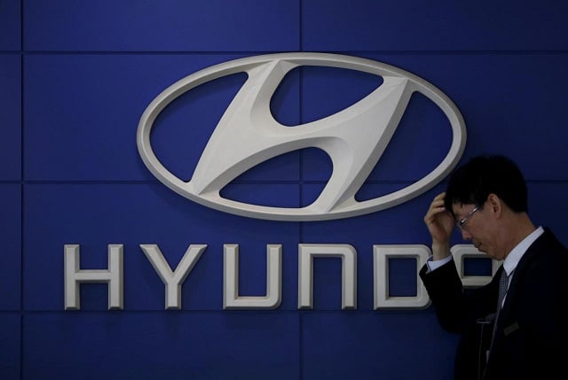 a car dealer stands in front of the logo of hyundai motor at its dealership in seoul south korea april 25 2016 photo reuters