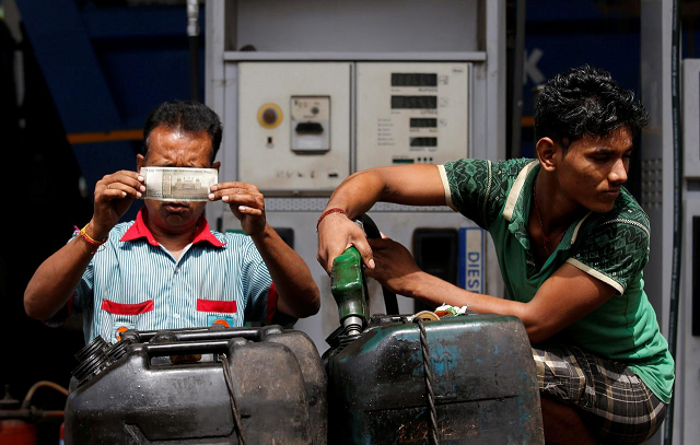 a worker checks a 500 indian rupee note as a man fills diesel in containers at a fuel station in kolkata india august 14 2018 photo reuters a worker checks a 500 indian rupee note as a man fills diesel in containers at a fuel station in kolkata india august 14 2018 photo reuters