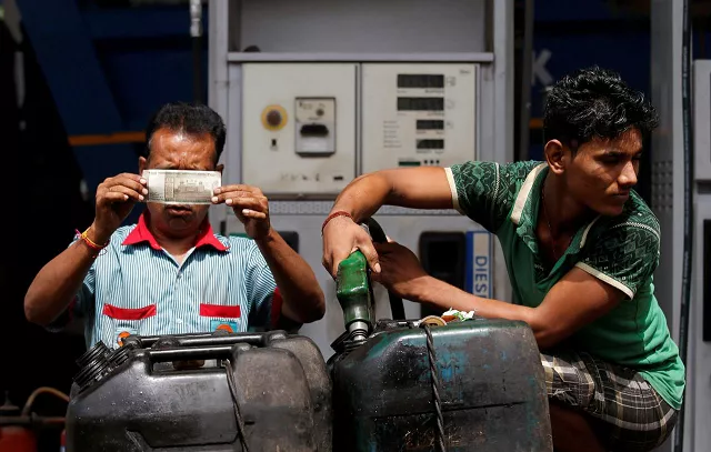 a worker checks a 500 indian rupee note as a man fills diesel in containers at a fuel station in kolkata india august 14 2018 photo reuters a worker checks a 500 indian rupee note as a man fills diesel in containers at a fuel station in kolkata india august 14 2018 photo reuters