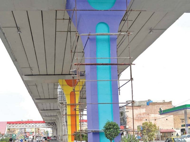 workers paint pillars of metro bus track near liaquat bagh in rawalpindi photo inp workers paint pillars of metro bus track near liaquat bagh in rawalpindi photo inp