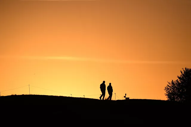 men walk on a fairway at sunrise ahead of the 42nd ryder cup at le golf national course in france photo afp