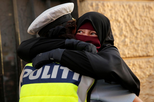 a danish policewoman embraces a niqab clad protester photo reuters