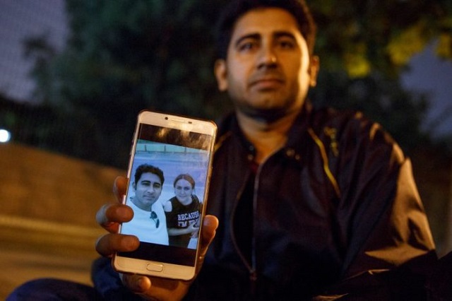 pakistani businessman mirza imran baig shows a picture of him and his wife mailikemu maimati as he sits outside the pakistani embassy in beijing china photo reuters