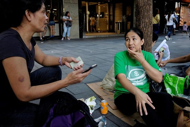 we remit volunteer jona de cuia chats with joslyn pimentero a domestic helper at the financial central district in hong kong china september 2 2018 photo reuters we remit volunteer jona de cuia chats with joslyn pimentero a domestic helper at the financial central district in hong kong china september 2 2018 photo reuters