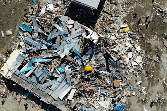 this aerial photo shows earthquake survivors searching for items they can salvage amongst the debris in palu on october 1 2018 after an earthquake and tsunami hit the area on september 28   mass graves were being readied on october 1 for hundreds of victims of the indonesian quake and tsunami as authorities battled to stave off disease and reach desperate people still trapped under shattered buildings photo afp