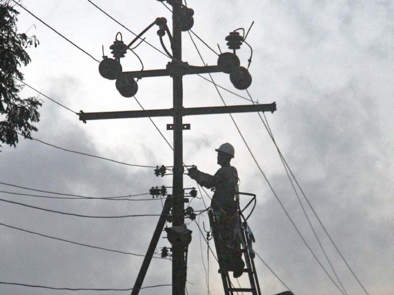 a k electric employee repairs electric wires on a pole in north nazimabad many localities in the city plunged into darkness on tuesday due to the tripping of extra high tension wires photo online