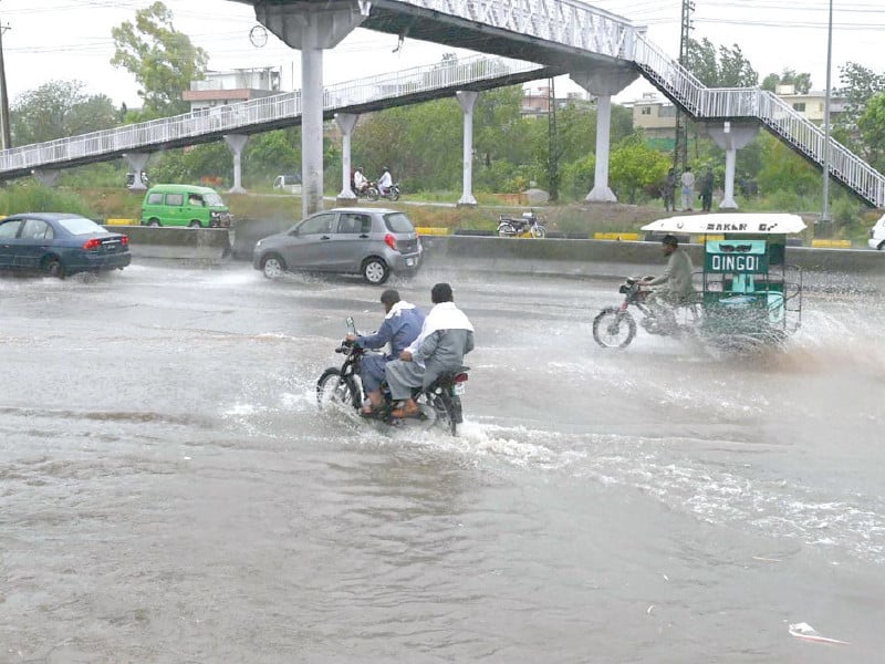 motorists drive through rainwater accumulated on ijp road after a heavy downpour in the federal capital on wednesday photo app