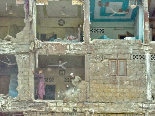 amid debris and dust workers carry out demolition of the rear section of gudda plaza of which some parts caved in earlier photo jalal qureshi express