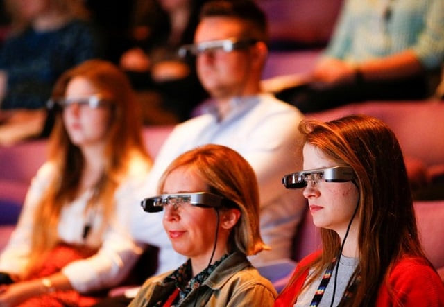 people watch a live performance of exit the king at the national theatre while wearing smart caption glasses designed by epson in london britain october 3 2018 photo reuters people watch a live performance of exit the king at the national theatre while wearing smart caption glasses designed by epson in london britain october 3 2018 photo reuters
