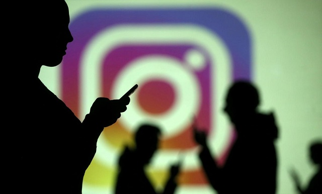 silhouettes of mobile users are seen next to a screen projection of instagram logo in this picture illustration taken march 28 2018 photo reuters