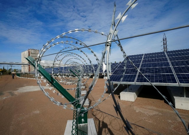 solar panels are seen through barbed wire at a solar power plant built on the site of the world 039 s worst nuclear disaster chernobyl ukraine photo reuters