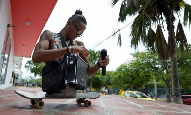 with a boom box and microphone 25 year old alfonso quot alca quot mendoza who was born without legs belts out rap songs on buses in colombia then rolls down the aisle on his skateboard to collect his tips photo afp