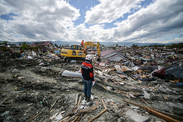 a member of an indonesian search and rescue team looks at the debris in petobo in central sulawesi photo afp a member of an indonesian search and rescue team looks at the debris in petobo in central sulawesi photo afp