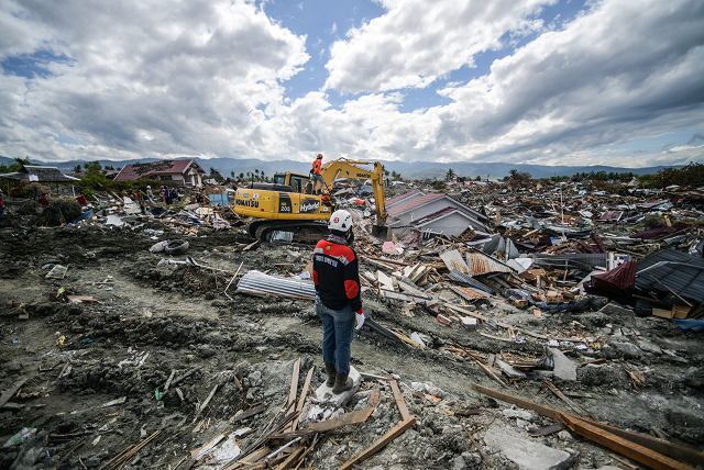 a member of an indonesian search and rescue team looks at the debris in petobo in central sulawesi photo afp