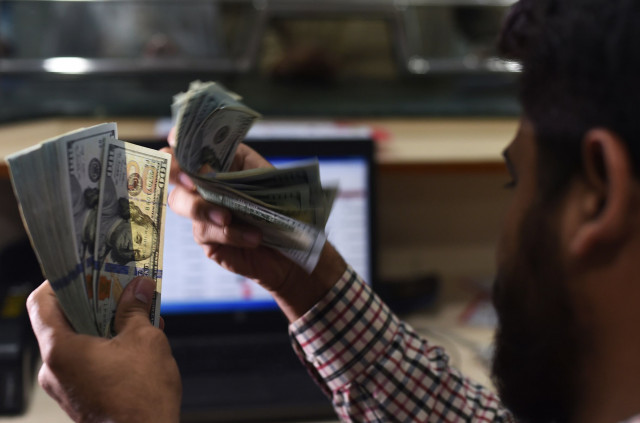 a dealer counting us dollars at a currency exchange in karachi on october 9 photo afp a dealer counting us dollars at a currency exchange in karachi on october 9 photo afp