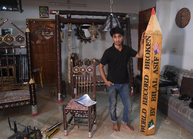 pakistani artist bilal asif works on his pencils artwork at his studio in karachi   with a sharp eye for detail bilal asif carefully files down pencils in his studio as part of a quest to set a world record for creating the largest swing made from pencil parts photo afp