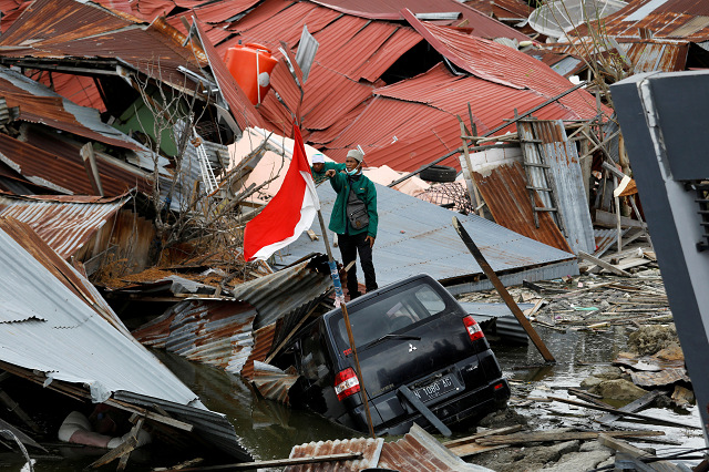 a man gestures towards a search and rescue team while looking for victims in the earthquake and liquefaction affected balaroa neighbourhood in palu photo reuters