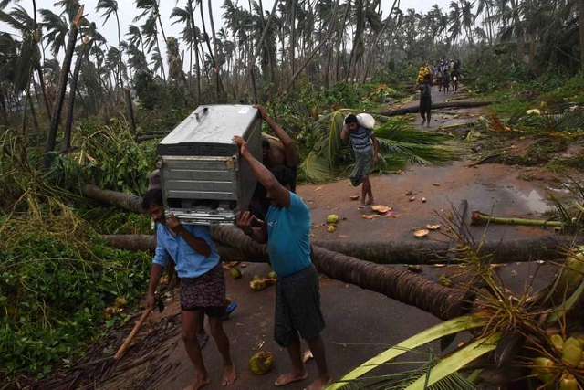 people carry their belongings to a safer place after cyclone titli hit in srikakulam district in the southern state of andhra pradesh india october 11 2018 photo reuters