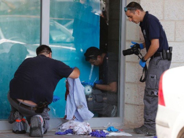 israeli forensic policemen inspect the site where an israeli man was fatally stabbed by a palestinian near a mall at the gush etzion junction near bethlehem in the occupied west bank photo afp