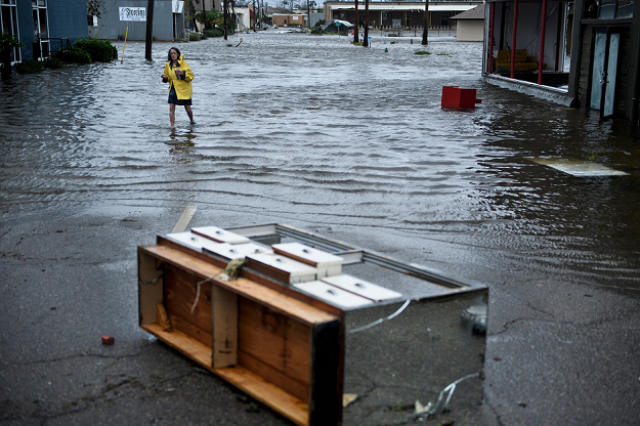 a woman crosses a flooded street after hurricane michael photo afp a woman crosses a flooded street after hurricane michael photo afp