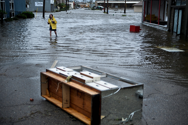 a woman crosses a flooded street after hurricane michael photo afp