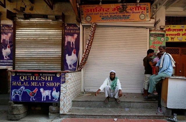 people sit outside the closed meat shops in gurugram india photo reuters people sit outside the closed meat shops in gurugram india photo reuters