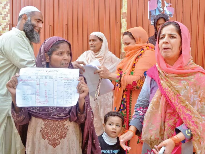 a woman shows to the media the lease deed of her property along korang nullah photo waseem nazir express