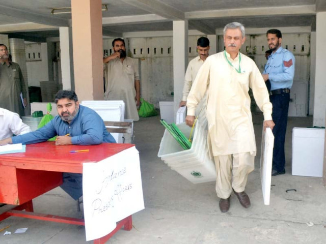 a polling official carries of election material for by polls in islamabad photo waseem nazir express