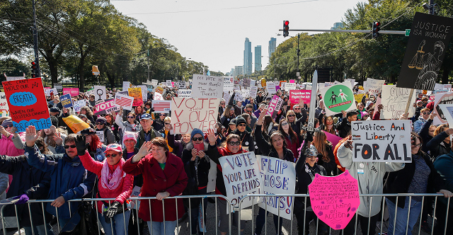 people hold signs during a rally and march at grant park in chicago illinois photo afp people hold signs during a rally and march at grant park in chicago illinois photo afp