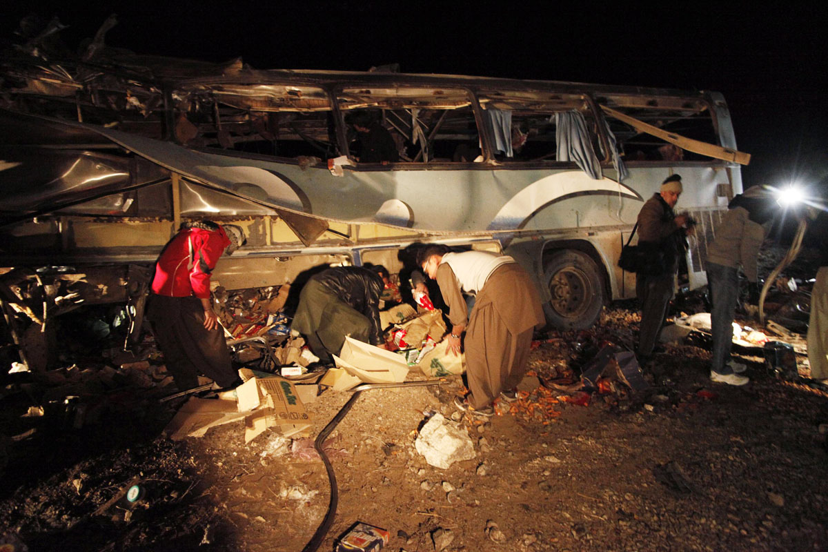 rescue workers collect evidence from a burnt passenger bus on the outskirts of quetta january 21 2014 photo reuters