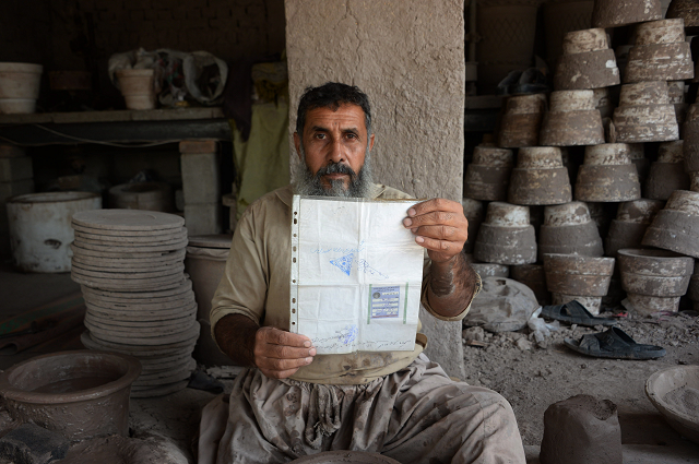 potter shirin agha 45 poses for a picture holding his tazkira photo afp