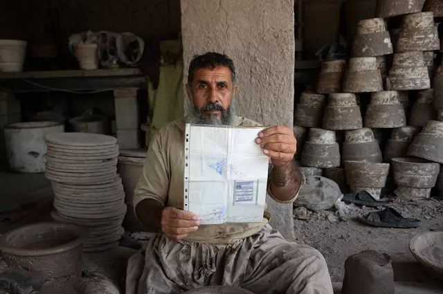 potter shirin agha 45 poses for a picture holding his tazkira photo afp potter shirin agha 45 poses for a picture holding his tazkira photo afp