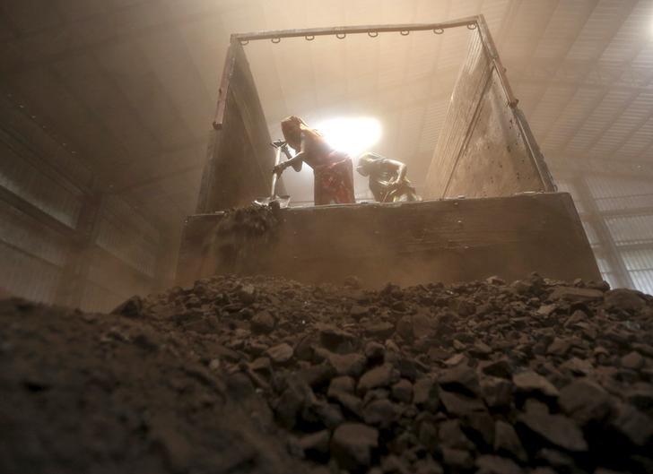 workers unload coal from a supply truck at a yard photo reuters