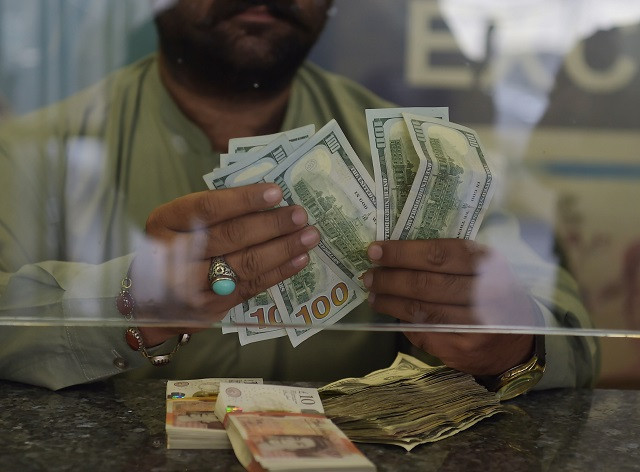 a currency dealer counts us dollars at a currency exchange shop in islamabad on october 9 photo afp a currency dealer counts us dollars at a currency exchange shop in islamabad on october 9 photo afp