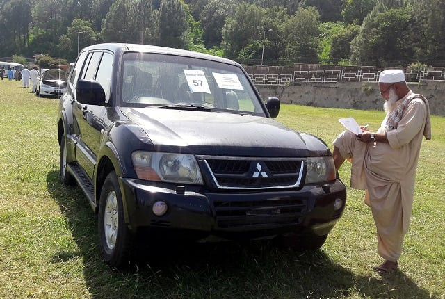 a man writes down the details of a government owned car on sale during an auction at the premises of pm house in islamabad sept 17 2018 photo reuters a man writes down the details of a government owned car on sale during an auction at the premises of pm house in islamabad sept 17 2018 photo reuters