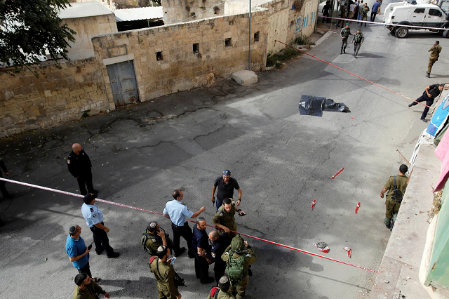 the dead body of a palestinian is covered as israeli forces gather at the scene of a stabbing attack in hebron in the occupied west bank october 22 2018 photo reuters