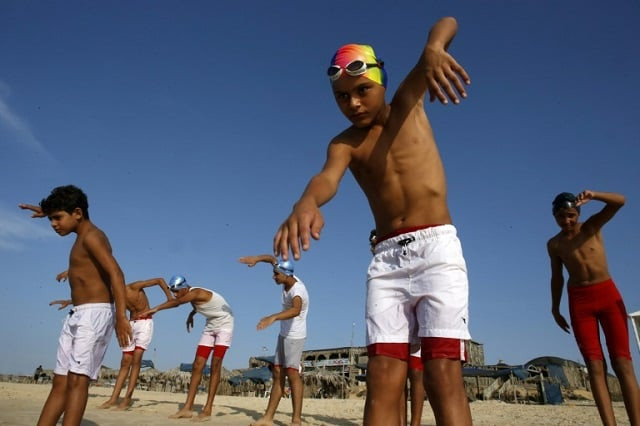 young members of a palestinian swimming club excercise on a beach during a training session in beit lahia in the northern gaza strip on october 4 2018 photo afp young members of a palestinian swimming club excercise on a beach during a training session in beit lahia in the northern gaza strip on october 4 2018 photo afp