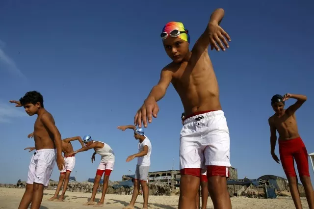 young members of a palestinian swimming club excercise on a beach during a training session in beit lahia in the northern gaza strip on october 4 2018 photo afp young members of a palestinian swimming club excercise on a beach during a training session in beit lahia in the northern gaza strip on october 4 2018 photo afp
